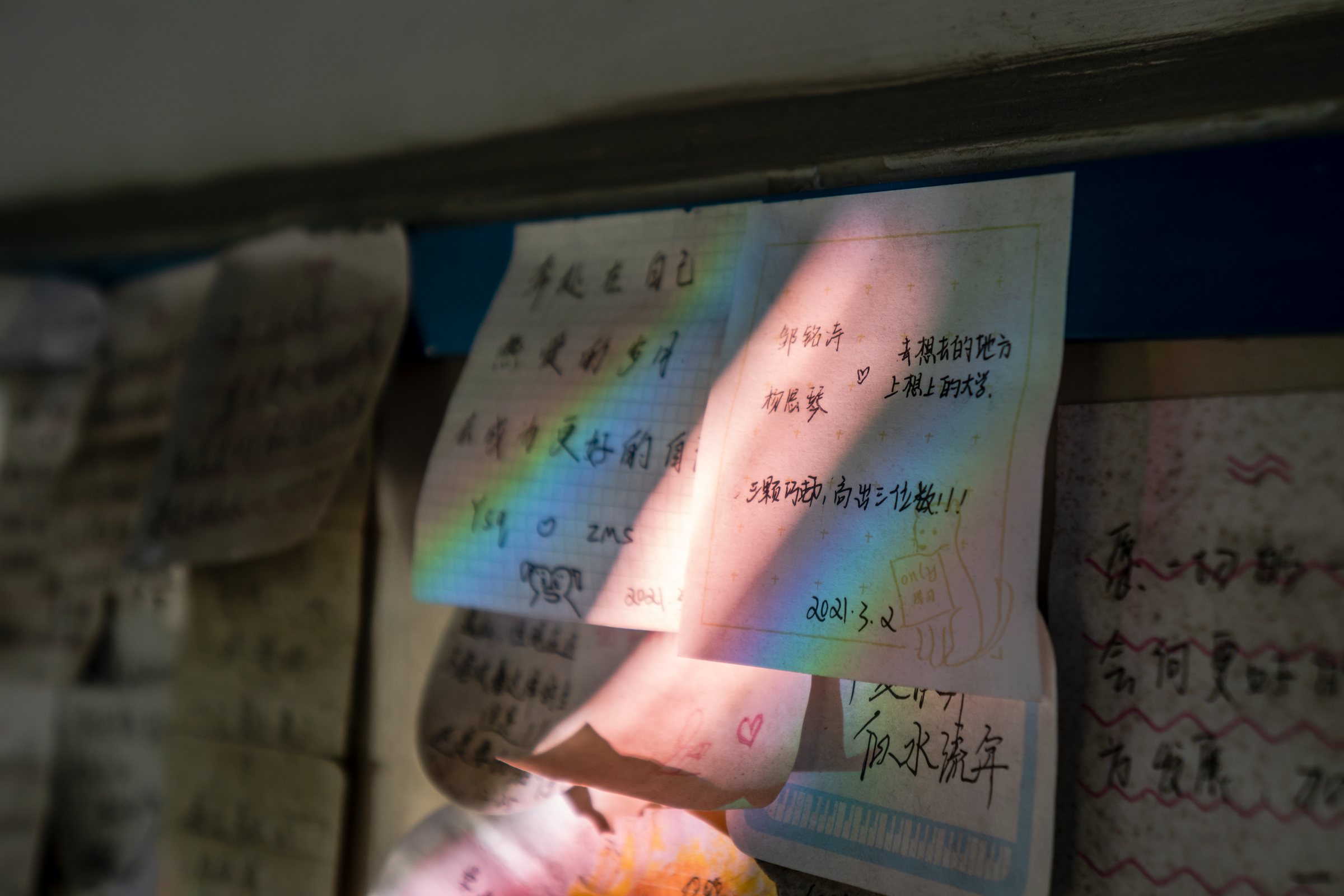 层层叠叠的笔迹被光照亮，留着许多没有署名的祝愿。